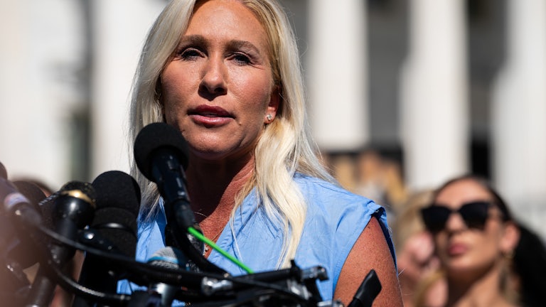 Representative Marjorie Taylor Greene speaks into microphones outside the U.S. Capitol.