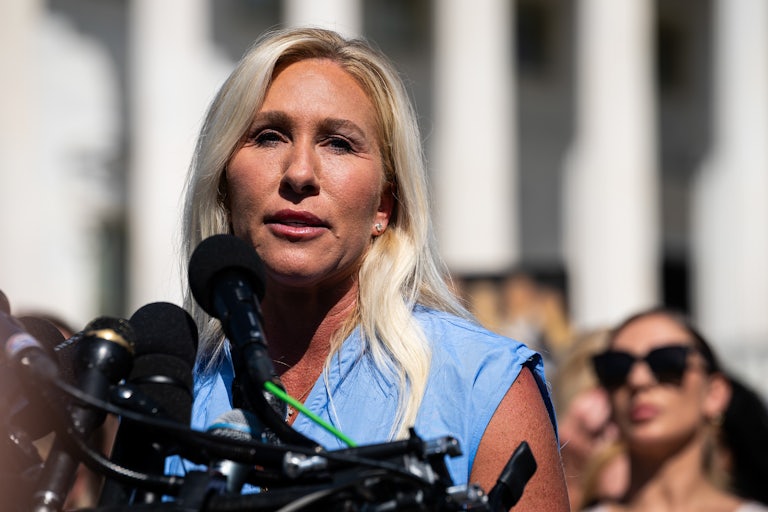 Representative Marjorie Taylor Greene speaks into microphones outside the U.S. Capitol.