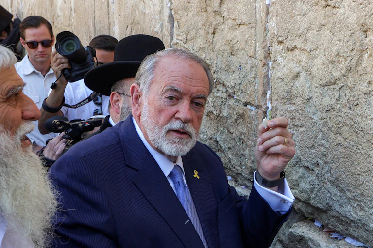 Mike Huckabee holds a paper at the Wailing Wall in Jeruslaem