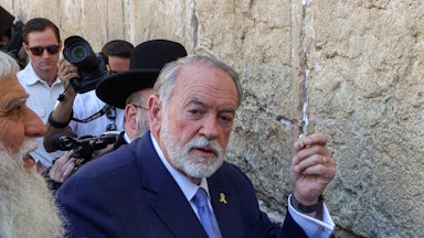 Mike Huckabee holds a paper at the Wailing Wall in Jeruslaem