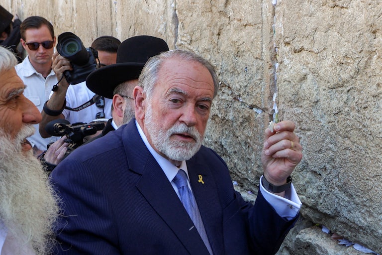 Mike Huckabee holds a paper at the Wailing Wall in Jeruslaem