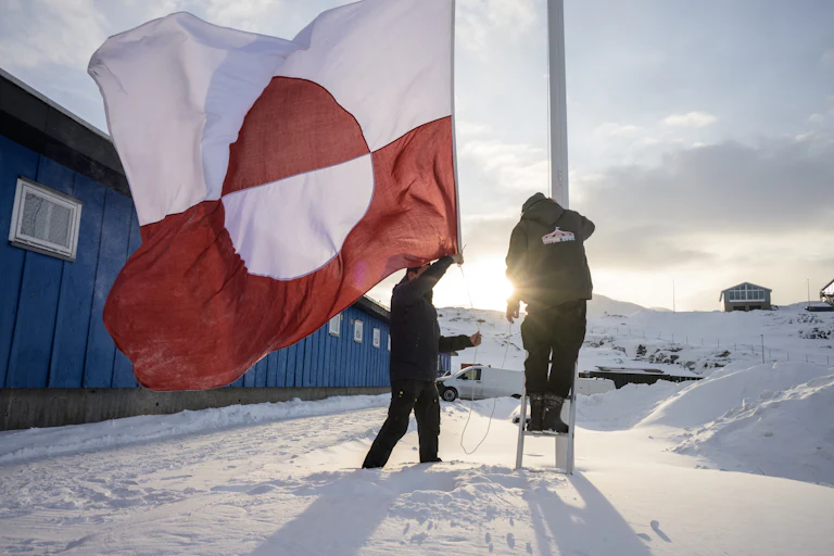 People raise a Greenlandic flag in Nuuk, Greenland
