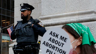 A police officer watched activists during the Abortion Carnival at St. Patrick’s Cathedral in New York City in 2022, months after the Supreme Court tore down Roe v. Wade.