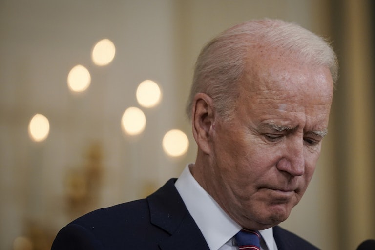 Joe Biden pauses and looks down at a press conference.