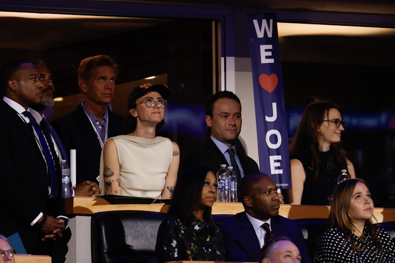 Ella Emhoff watches the proceedings during the first day of the Democratic National Convention. Others stand near her.