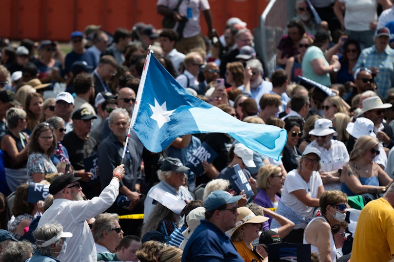 A supporter waves a Minnesota flag at a recent Harris/Walz event in Eau Claire, Wisconsin.