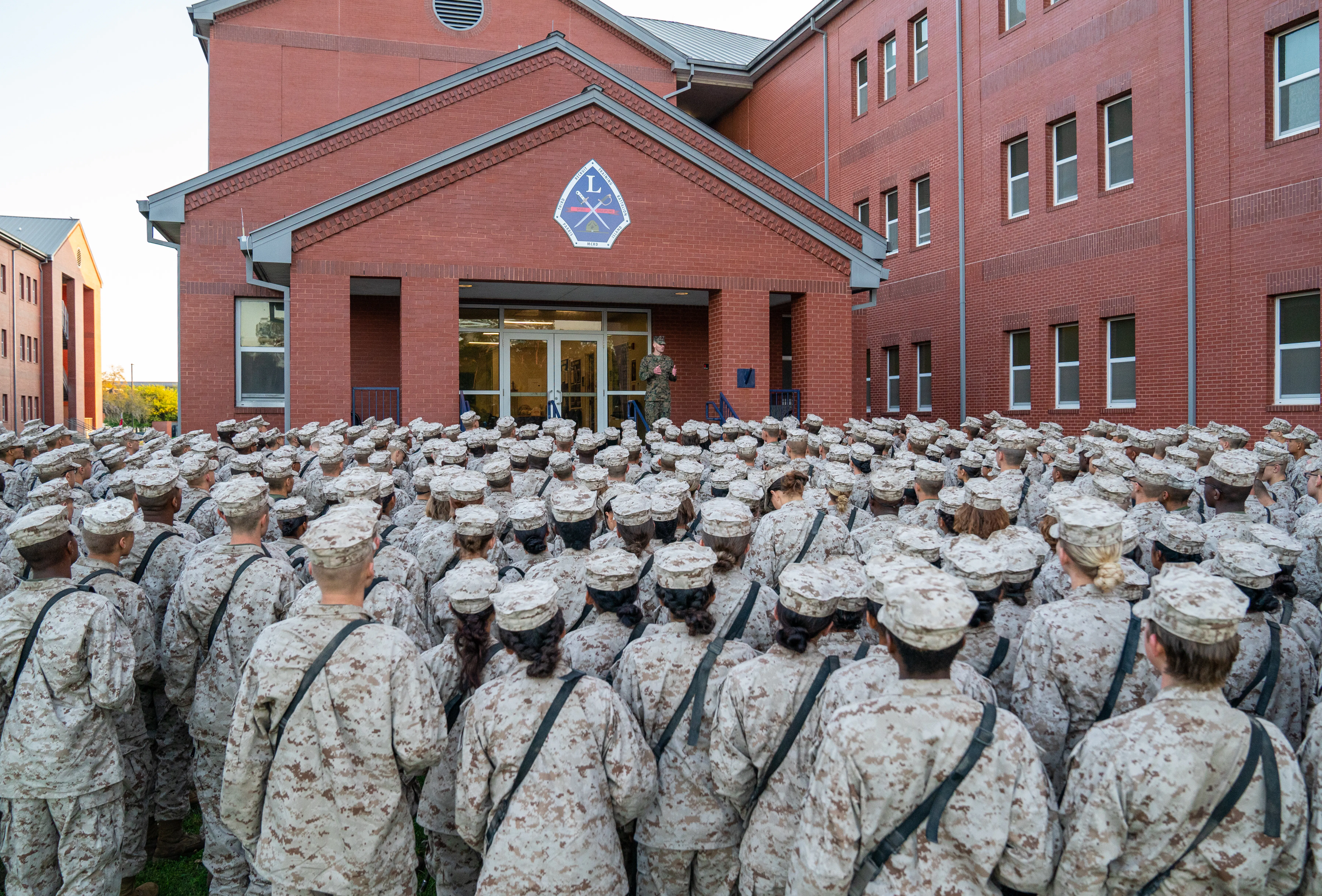 Marine recruits listen to someone speaking