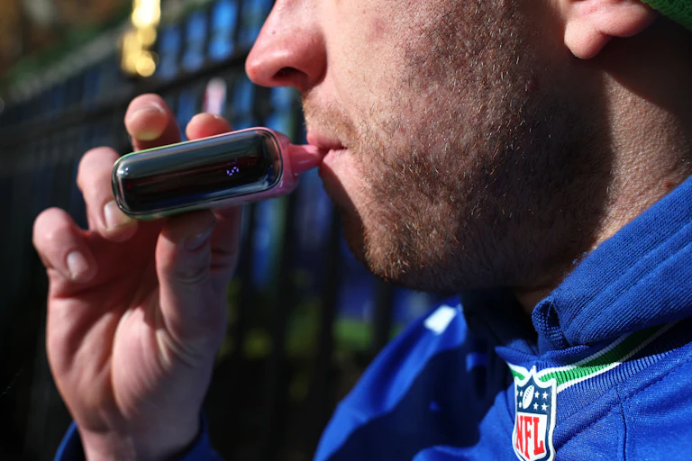 Someone smoking a pink vape
