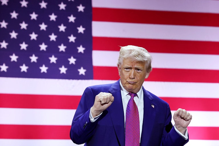 Donald Trump makes a duck face and dances with his fists raised
