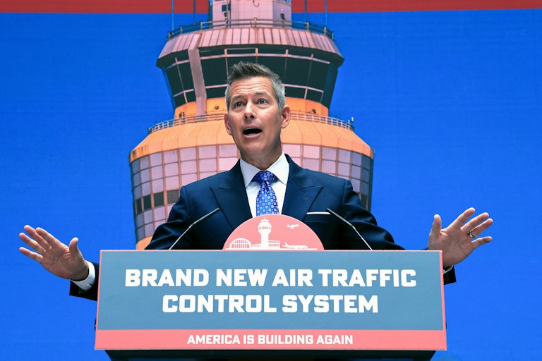 Transportation Secretary Sean Duffy gestures while speaking at a podium labeled "Brand New Air Traffic Control System"