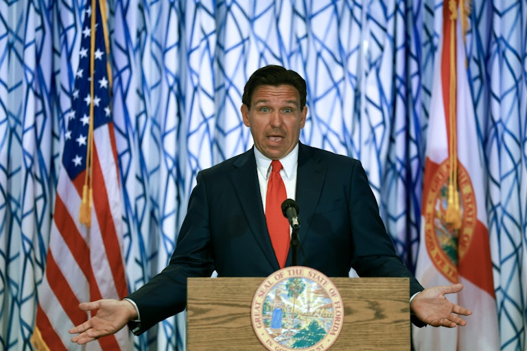 Ron DeSantis gestures as he stands at a podium