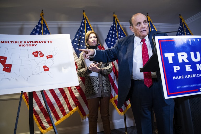 Rudy Giuliani, standing at a podium, points to a sign with a map of the United States and the title "Multiple Pathways to Victory"
