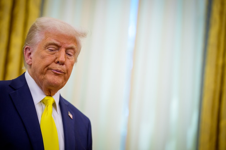 Donald Trump purses his lips while standing in the Oval Office