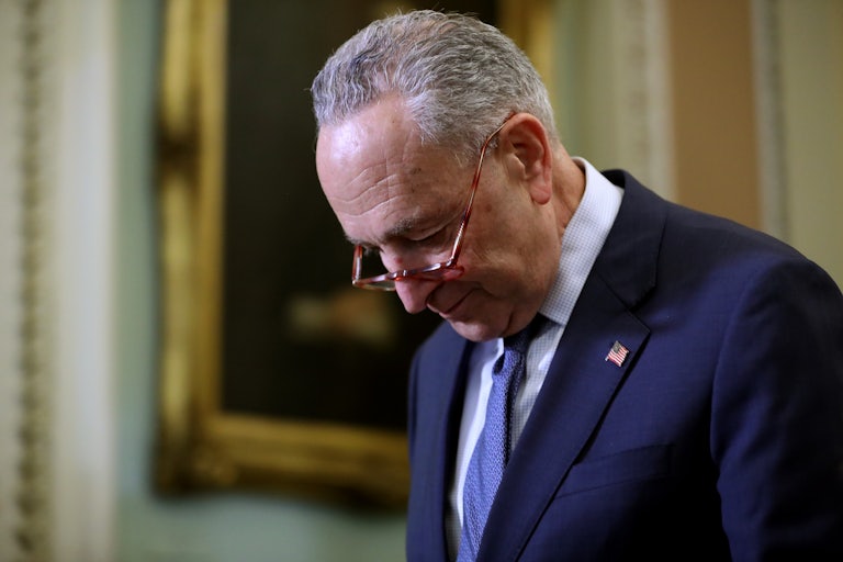 A close up of Senate Majority Leader Chuck Schumer bowing his head.