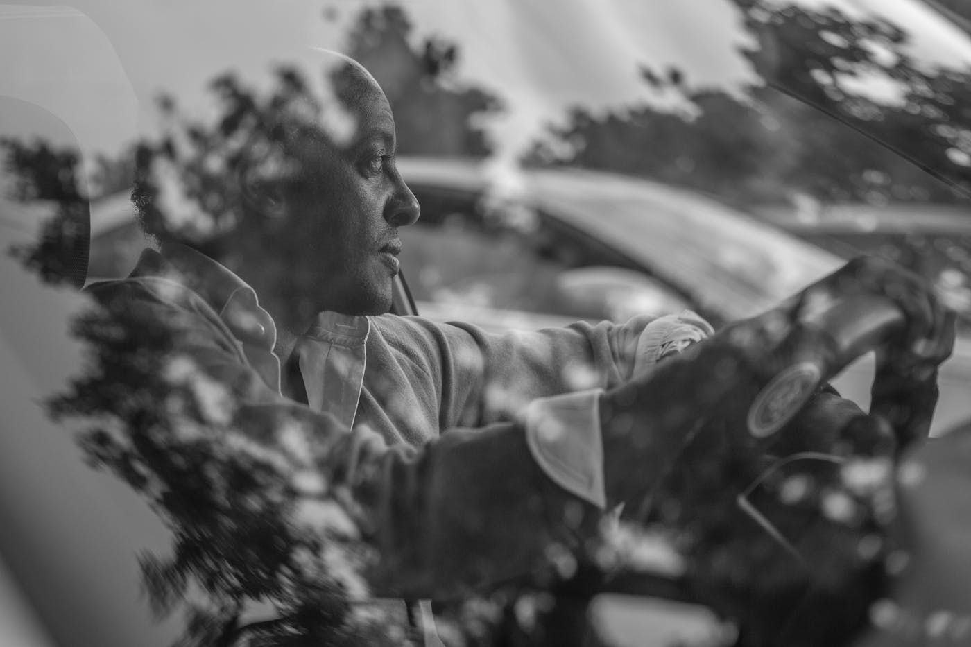 Dinaw Mengestu photographed inside a car with reflections on the window 