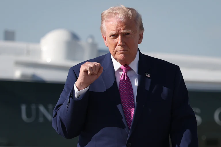 Donald Trump holds up a fist while walking