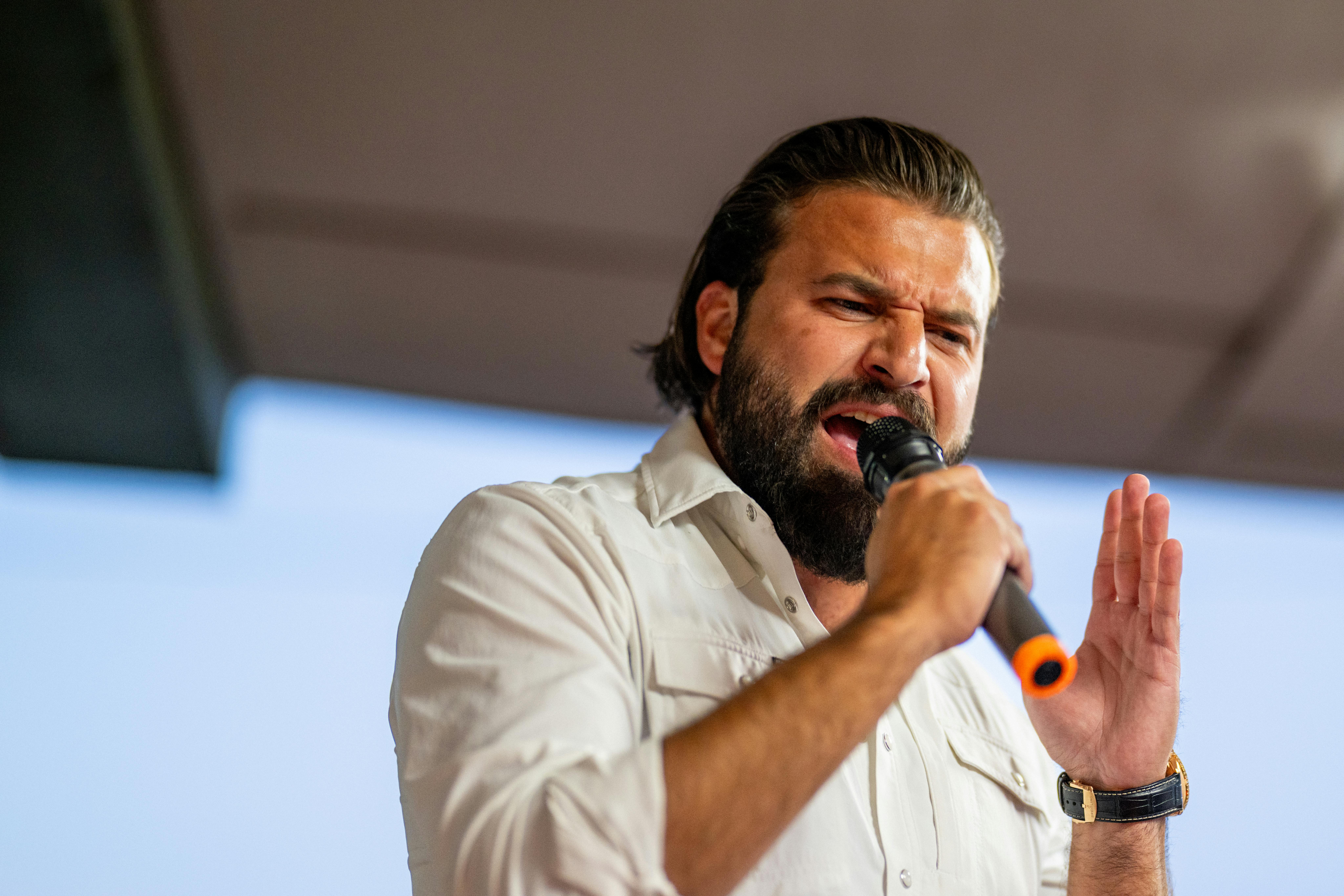 Brandon Herrera speaks aggressively into a microphone