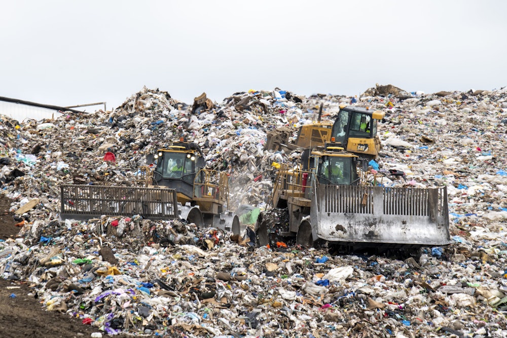 Large machinery rolls over hills of plastic debris.
