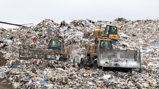 Large machinery rolls over hills of plastic debris.