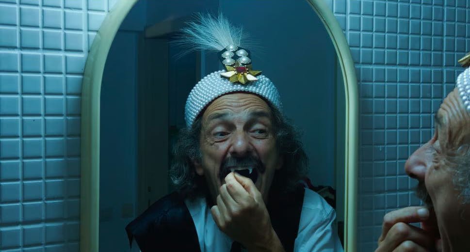 Gabriel Spahiu is Dracula, trying on costume fangs, in Radu Jude’s AI-infused horror