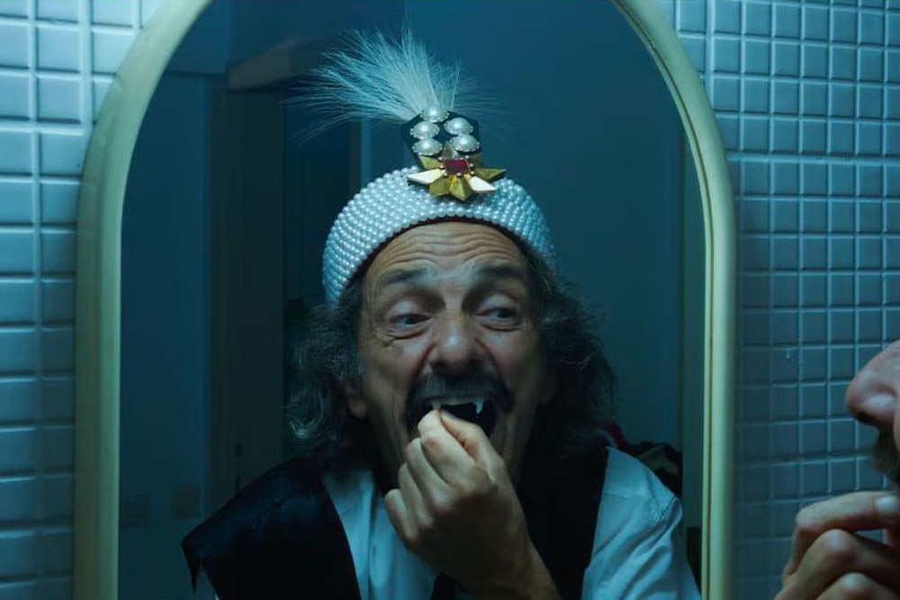 Gabriel Spahiu is Dracula, trying on costume fangs, in Radu Jude’s AI-infused horror