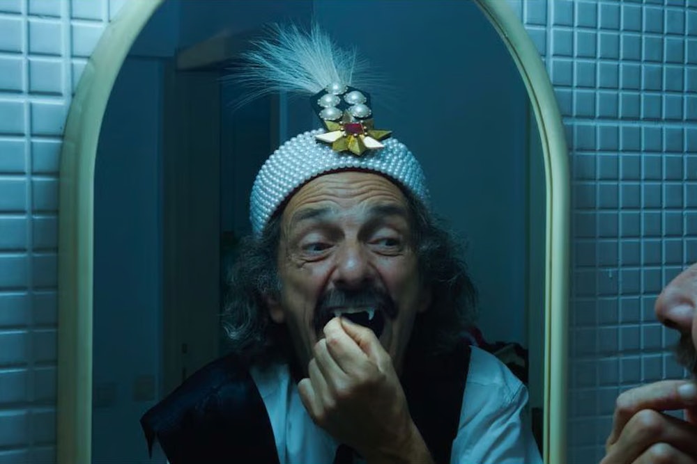 Gabriel Spahiu is Dracula, trying on costume fangs, in Radu Jude’s AI-infused horror