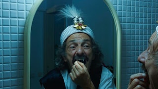 Gabriel Spahiu is Dracula, trying on costume fangs, in Radu Jude’s AI-infused horror