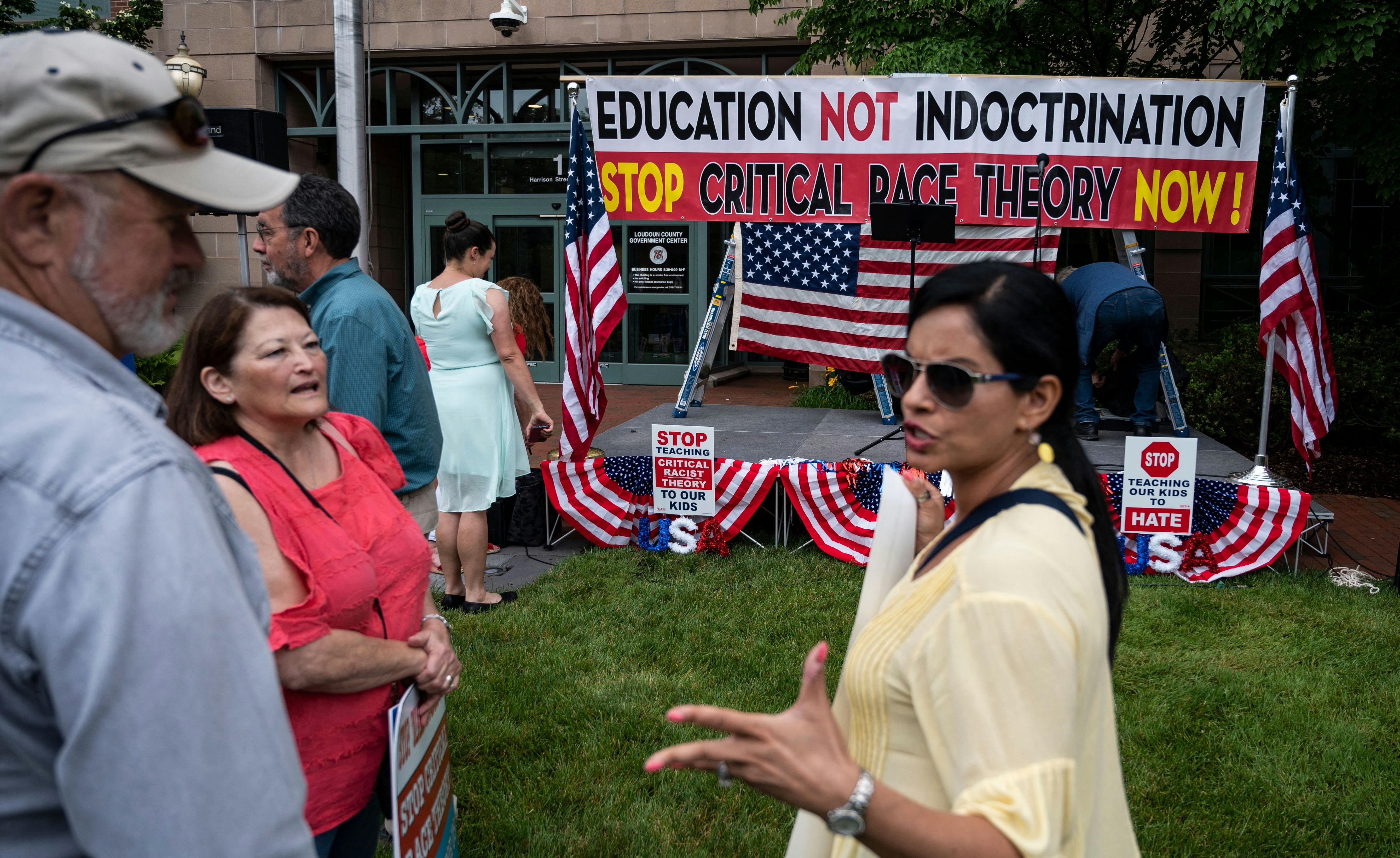 People talk before the start of a rally against "critical race theory" in Loudoun County, Virginia.