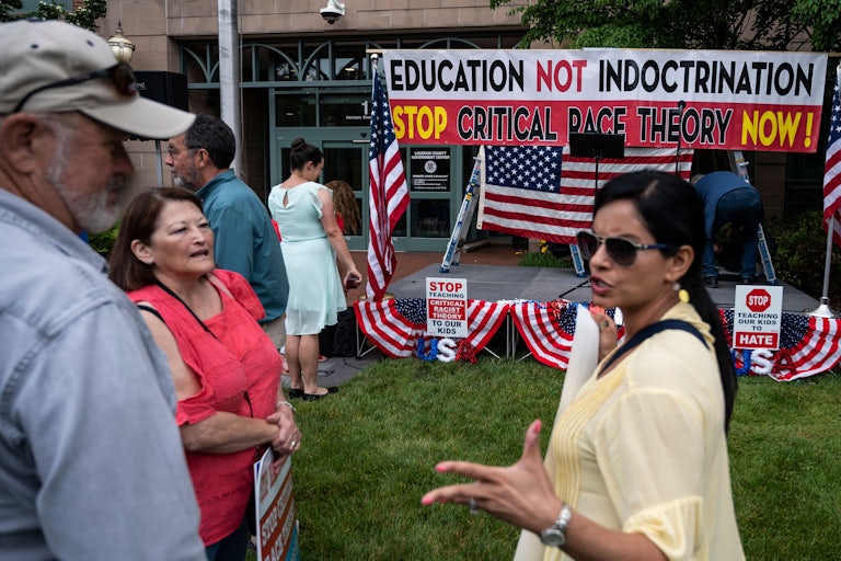 People talk before the start of a rally against "critical race theory" in Loudoun County, Virginia.