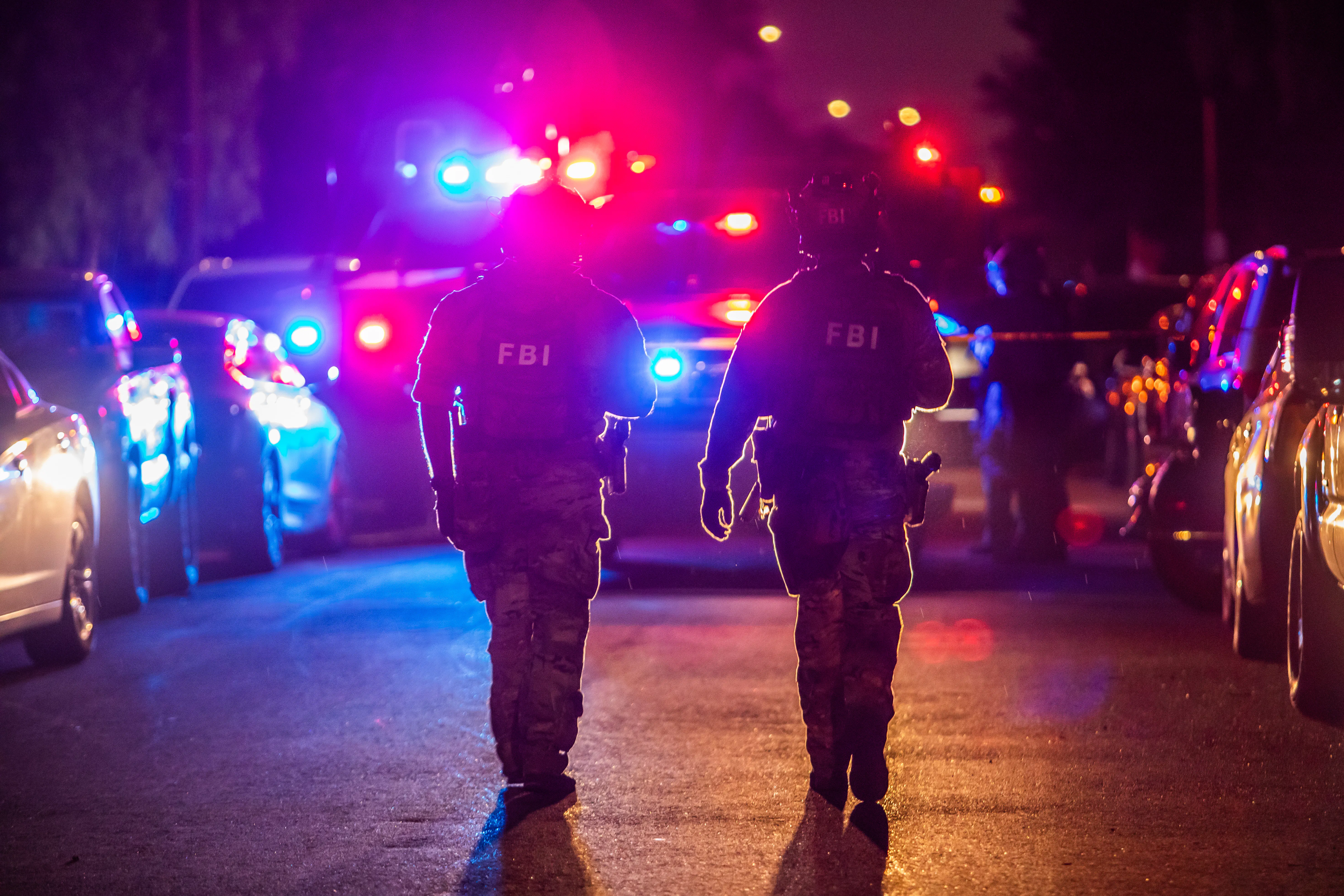 Law enforcement officers walk outside the home of the suspected White House Correspondents’s Dinner shooter in Torrance, California.