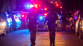 Law enforcement officers walk outside the home of the suspected White House Correspondents’s Dinner shooter in Torrance, California.
