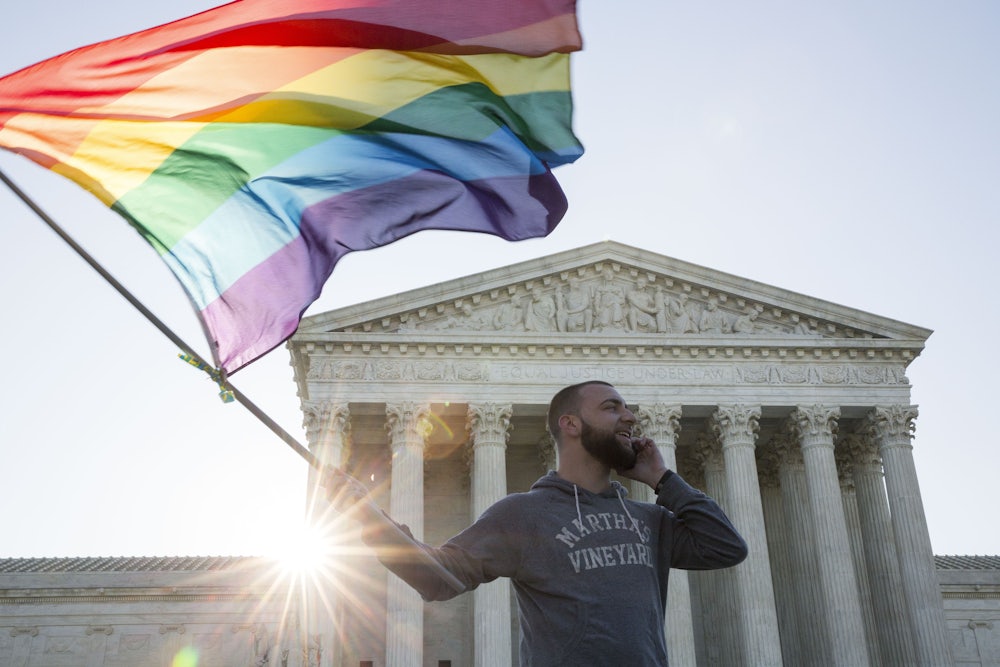 Same-sex marriage supporter Vin Testa waves a rainbow pride flag near the Supreme Court, April 28, 2015.