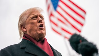 Donald Trump speaks vehemently with American flag in background