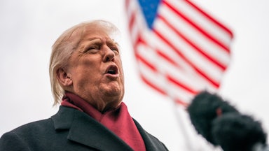 Donald Trump speaks vehemently with American flag in background