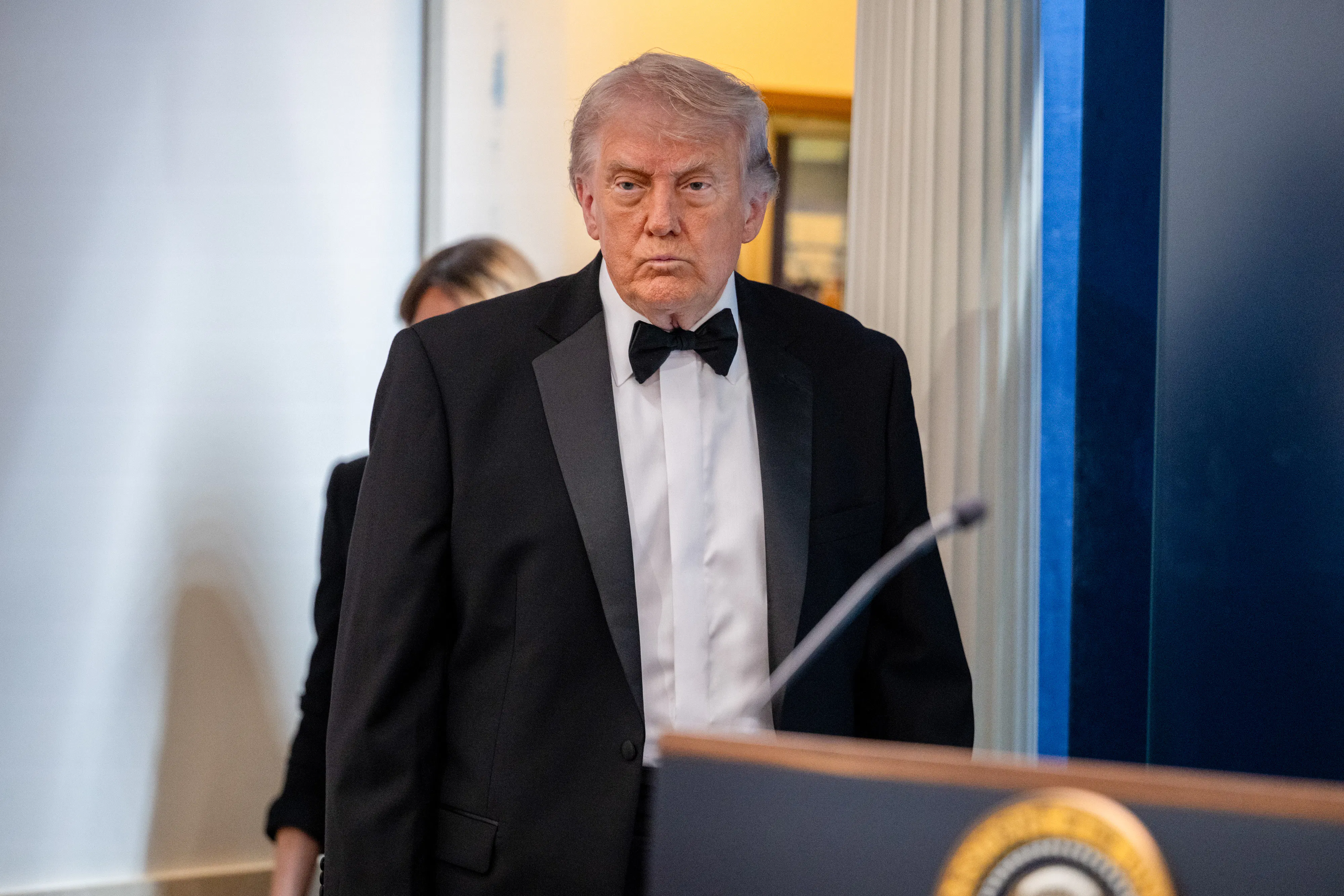 Donald Trump purses his lips while walking into the White House press briefing room