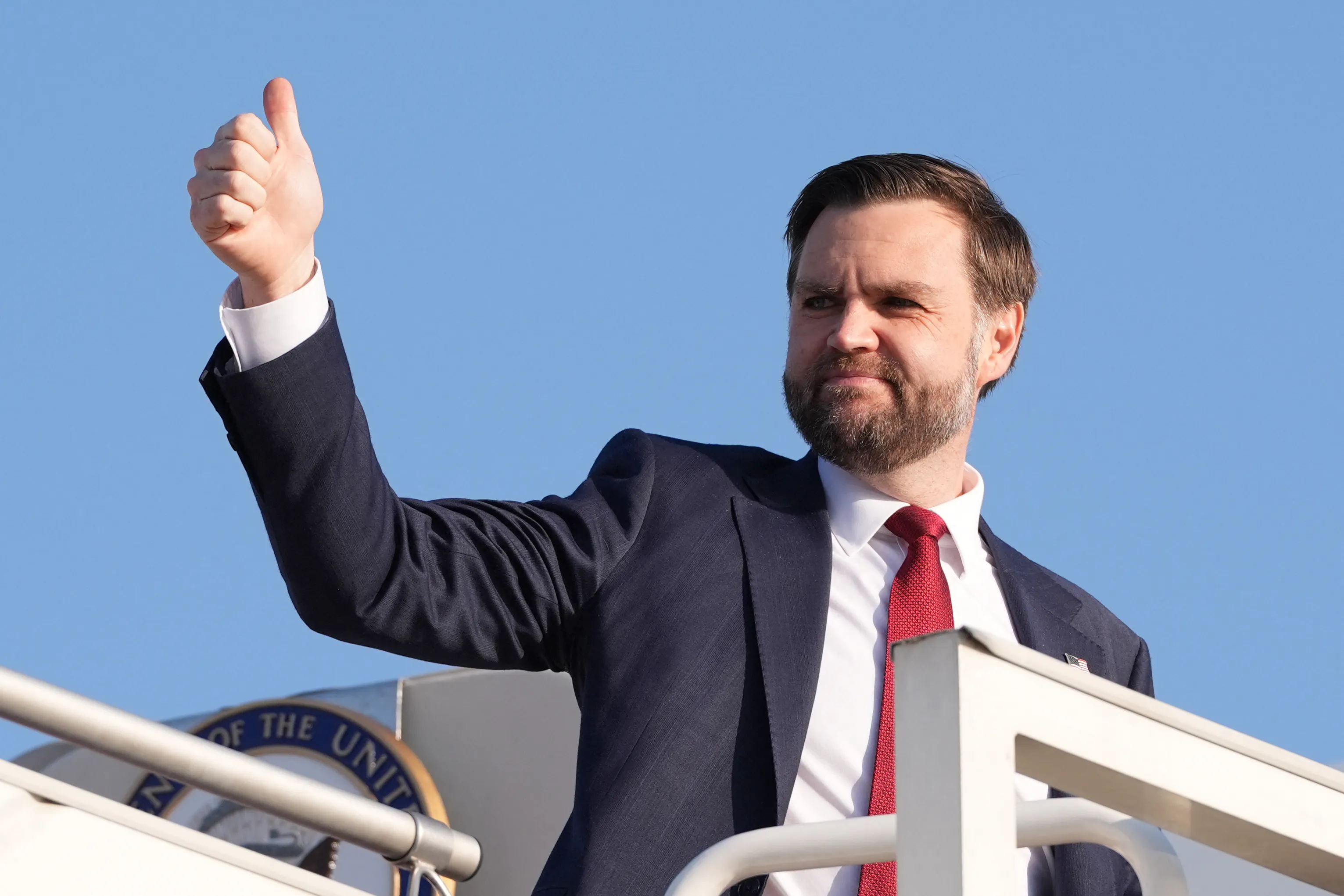 JD vance does a thumbs up while getting on a airplane