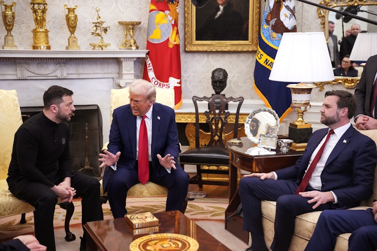 Donald Trump and Volodomyr Zelenskiy sit in chairs in the Oval Office, whlie JD Vance sits nearby on a couch. Trump is yelling and making animated hand gestures. The press pool watches.