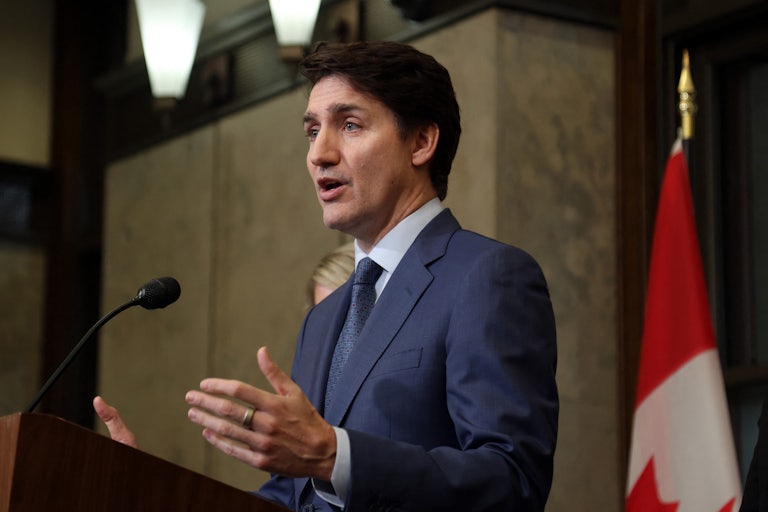 Canadian Prime Minister Justin Trudeau gestures while speaking at a podium during a press conference