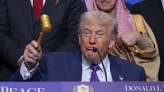 Donald Trump puckers his lips while holding up a gavel