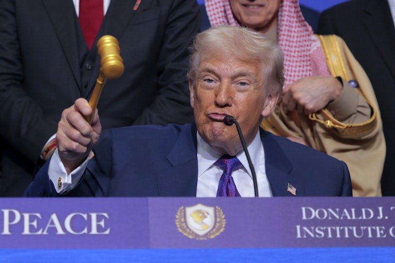 Donald Trump puckers his lips while holding up a gavel