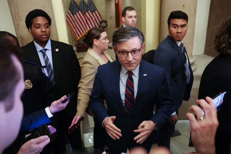 House Speaker Mike Johnson is surrounded by reporters holding phones in front of him to record what he says