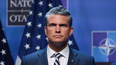 Defense Secretary Pete Hegseth stands on stage during Donald Trump’s press conference at the NATO summit in Turkey