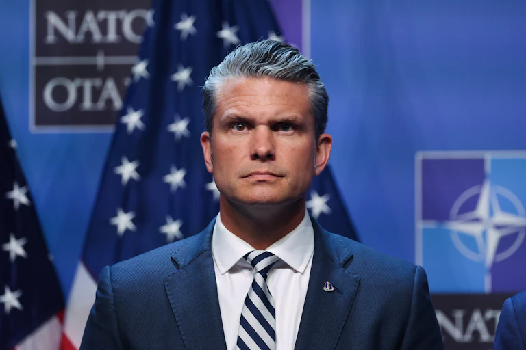 Defense Secretary Pete Hegseth stands on stage during Donald Trump’s press conference at the NATO summit in Turkey