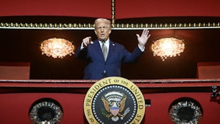 Donald Trump in a Kennedy Center balcony, speaking and pointing at the camera below. The shot makes him seem like a dictator.