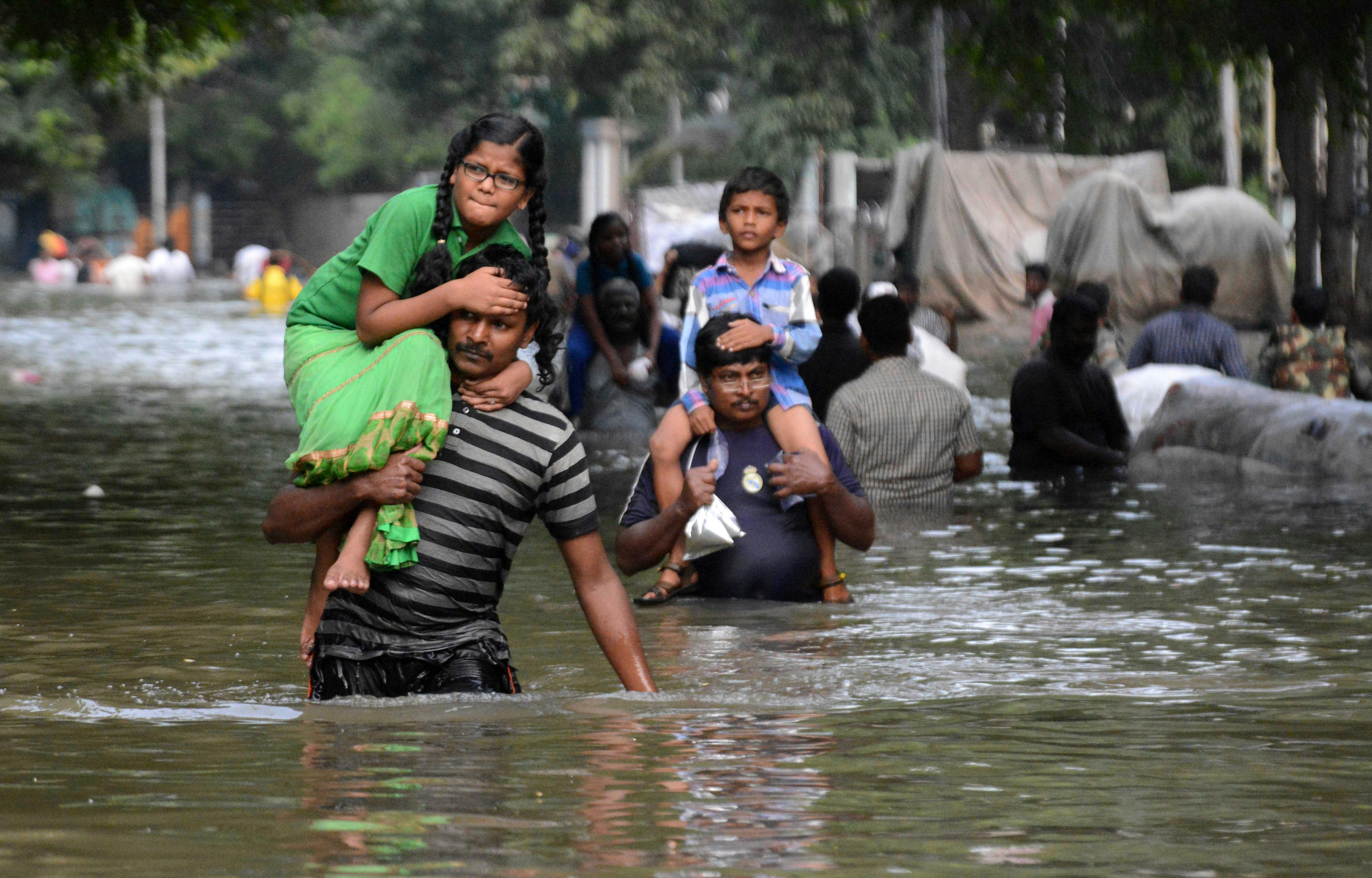 Chennai residents carry children through floodwaters in 2015.