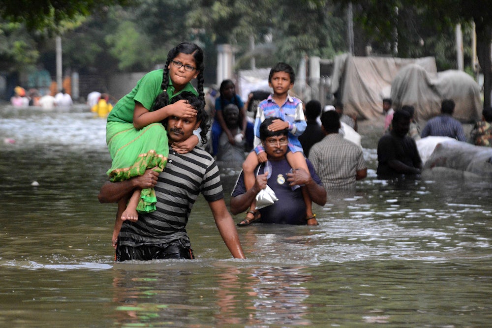 Chennai residents carry children through floodwaters in 2015.