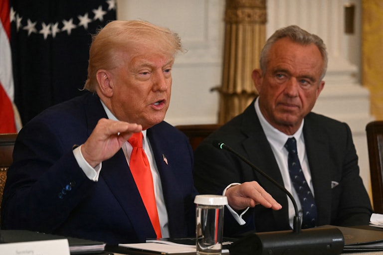 Donald Trump gestures and speaks while sitting next to Robert F. Kennedy Jr.