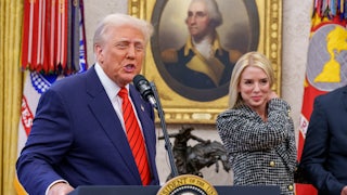 President Donald Trump speaks at the presidential podium while Attorney General Pam Bondi smiles beside him.