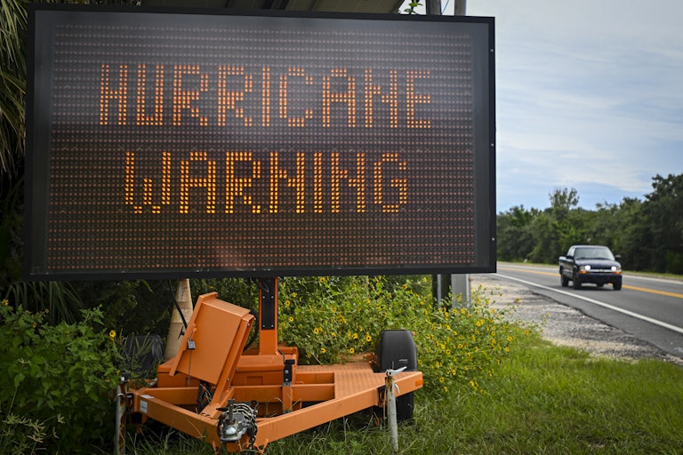 A sign displays a hurricane warning along a roadside as preparations are made for the arrival of Hurricane Helene, in Cedar Key, Florida on September 25, 2024.