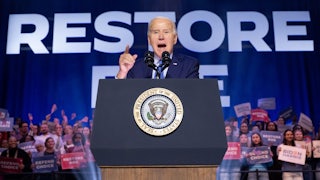Joe Biden speaks in front of a banner reading "Restore Roe."